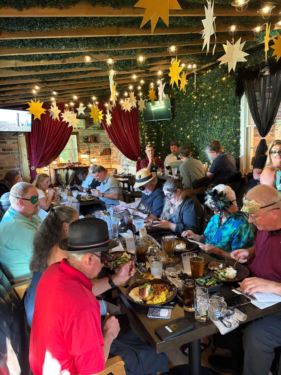 Guests in masks enjoying a themed murder mystery dinner at The Oak and Ivy Taphouse